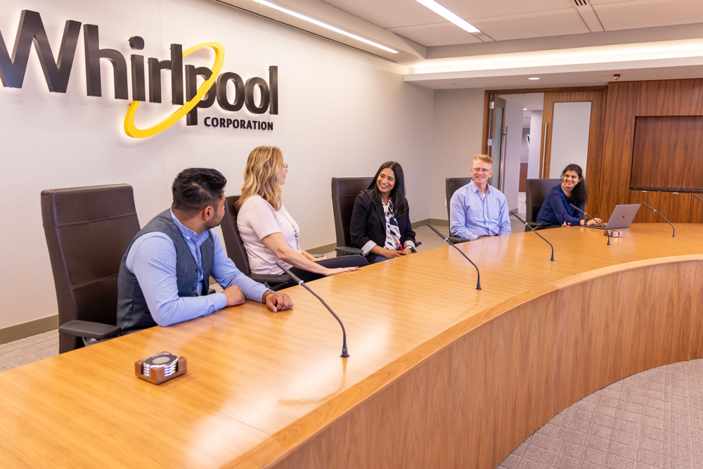 Pay Practices 5 Whirlpool employees talking in a conference room